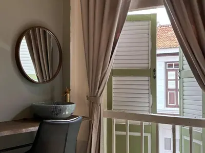 a bathroom with a mirror and a sink and a window at New! 9 pax Georgetown Heritage Pre-war House 3BR in George Town