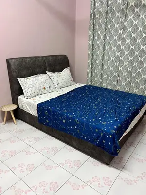 a bedroom with a bed with a blue comforter at Faza Homestay Meru Ipoh in Ipoh