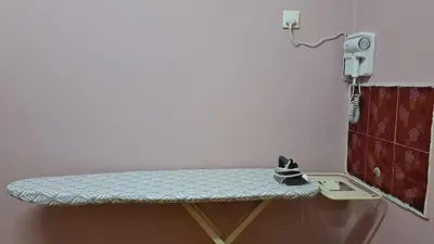 a table in a room with a phone on a wall at Faza Homestay Meru Ipoh in Ipoh