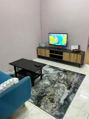 a living room with a tv and a table at Faza Homestay Meru Ipoh in Ipoh