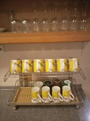a rack with yellow and white cups and spoons at Bayan Baru in Bayan Lepas