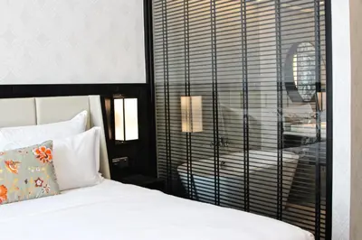 a bedroom with a bed and a window with a table at WEIL Hotel Ipoh in Ipoh
