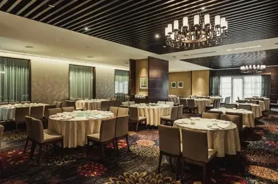a dining room with tables and chairs and a chandelier at WEIL Hotel Ipoh in Ipoh