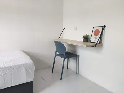 a desk with a chair next to a bed at Nixy Studio Seri Iskandar in Seri Iskandar