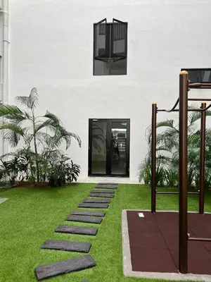 a building with a garden with grass and a walkway at Nixy Studio Seri Iskandar in Seri Iskandar