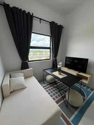 a living room with a white couch and a television at Nixy Studio Seri Iskandar in Seri Iskandar