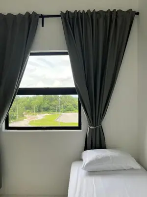 a bedroom with a window with black curtains and a bed at Nixy Studio Seri Iskandar in Seri Iskandar