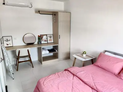 a bedroom with a pink bed and a chair at Nixy Studio Seri Iskandar in Seri Iskandar