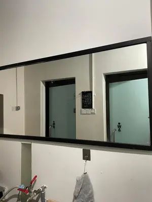 a large mirror in a bathroom with a sink at Homs Female Hostel in George Town