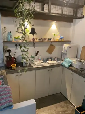 a kitchen with white cabinets and a counter top at Homs Female Hostel in George Town