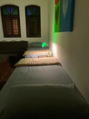 three mattresses lined up in a room with a lamp at Homs Female Hostel in George Town