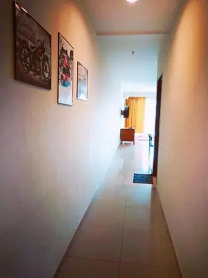 a hallway of a room with pictures on the wall at Marina HOMESTAY JETI LUMUT MANJUNG in Lumut