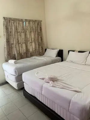 two beds sitting next to each other in a room at Hornbillbay Beach Resort in Kampung Teluk Nipah