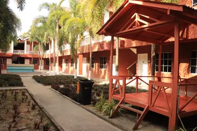 a bench in front of a building with palm trees at Hornbillbay Beach Resort in Kampung Teluk Nipah