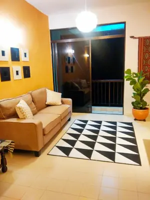 a living room with a couch and a checkered floor at Cozy & Comfy 3 rooms apartment near beach in Batu Ferringhi