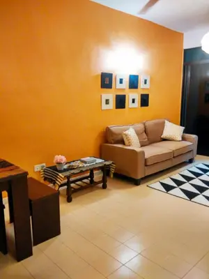 a living room with a couch and a table at Cozy & Comfy 3 rooms apartment near beach in Batu Ferringhi