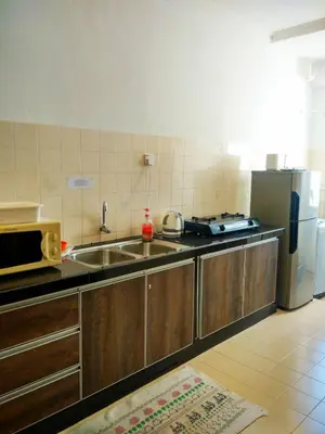 a kitchen with a sink and a refrigerator at Cozy & Comfy 3 rooms apartment near beach in Batu Ferringhi