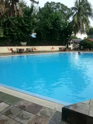 a large swimming pool with blue water in a resort at Cozy & Comfy 3 rooms apartment near beach in Batu Ferringhi