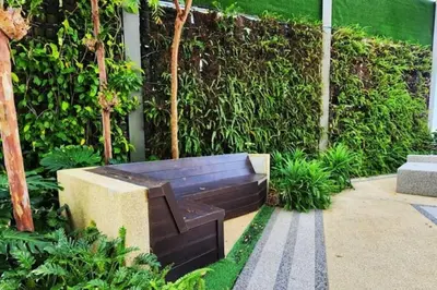 a wooden bench sitting in the middle of a garden at Seaview Studio Tropicana 218 Macalister Georgetown in George Town