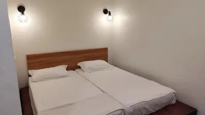 a bedroom with two beds and two lights on the wall at Scotland 18 Lodge in George Town