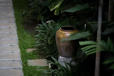 a large vase sitting in the middle of a garden at Muntri Grove in George Town