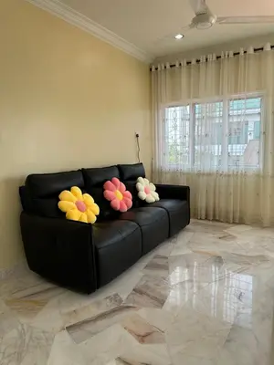 a black couch with flowers on it in a living room at UncleLiew Cozy Home \u8001\u5218\u6c11\u5bbf in Sekincan