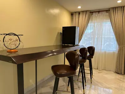a bar with two stools and a television in a room at UncleLiew Cozy Home \u8001\u5218\u6c11\u5bbf in Sekincan