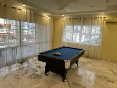 a pool table in a room with windows at UncleLiew Cozy Home \u8001\u5218\u6c11\u5bbf in Sekincan