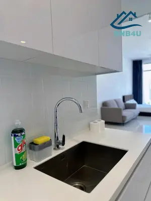 a kitchen counter with a sink and a couch at Beacon 2BR Infinity Pool - By BNB4U in George Town