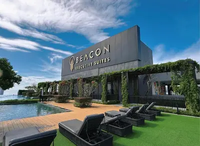 a hotel with a row of chairs in front of a building at Beacon 2BR Infinity Pool - By BNB4U in George Town
