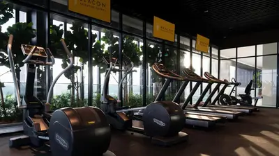 a row of treadmills in a gym with windows at Beacon 2BR Infinity Pool - By BNB4U in George Town