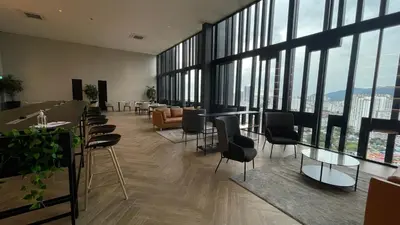a lobby with chairs and tables and large windows at Beacon 2BR Infinity Pool - By BNB4U in George Town