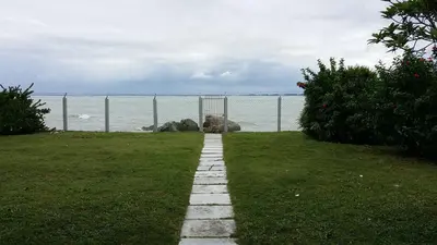 a stone path leading to the ocean with a fence at Beach Front Bungalow Tanjung Bungah in George Town