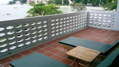 a balcony with a bench and a table and a fence at Beach Front Bungalow Tanjung Bungah in George Town