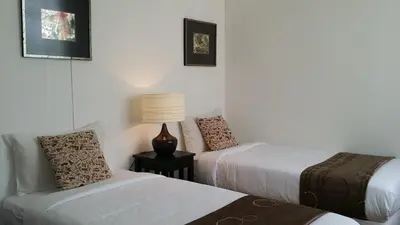 a room with two beds and a lamp on a table at Beach Front Bungalow Tanjung Bungah in George Town