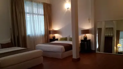 a hotel room with two beds and a mirror at Beach Front Bungalow Tanjung Bungah in George Town