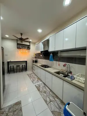 a large kitchen with white cabinets and a table at Homestay Bagan Serai in Bagan Serai