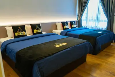 two beds in a hotel room with blue sheets at Hotel Lavie at Centrum in Brinchang