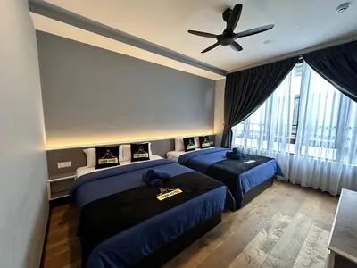 a bedroom with two beds and a ceiling fan at Hotel Lavie at Centrum in Brinchang