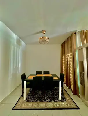 a dining room with a table and chairs and a chandelier at Aura Homestay in Sungai Petani