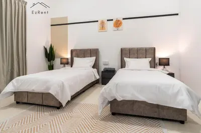 two beds in a bedroom with white walls at Black & White 4BR Semi-D Home for 10 Guests with Pool Table Games & Free Netflix WiFi in Taiping