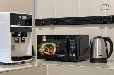 a microwave sitting on a kitchen counter next to a coffee maker at Black & White 4BR Semi-D Home for 10 Guests with Pool Table Games & Free Netflix WiFi in Taiping