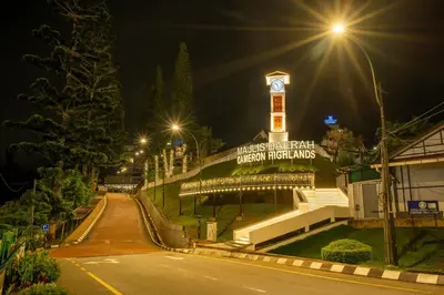 a building with a clock tower at night at Zenith Suites Cameron in Tanah Rata