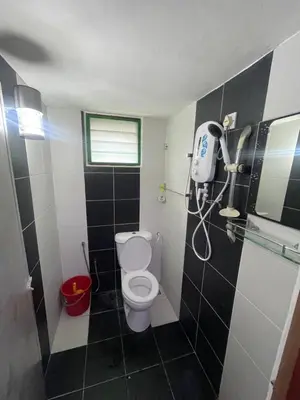 a bathroom with a toilet and a shower in it at Nami Homestay Teluk Batik in Lumut
