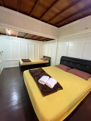 a bedroom with two beds with towels on it at Nami Homestay Teluk Batik in Lumut