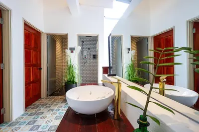 a bathroom with two sinks and a tub and a plant at 35 Cozy Homestay with projector Pool BBQ evcharger in Ipoh