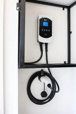 a phone on a shelf with a cord plugged into it at 35 Cozy Homestay with projector Pool BBQ evcharger in Ipoh