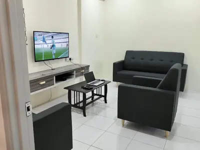 a living room with a couch and a chair and a television at City View Apartment in Ipoh