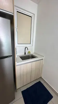 a kitchen with a sink with a mirror and a refrigerator at Southbay Seaview Condo A10 10minQueensbay 10minSpice in Bayan Lepas
