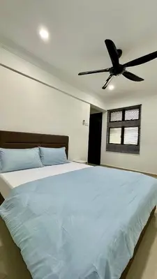 a bedroom with a bed with a ceiling fan at Pengo Homestay Georgetown in George Town